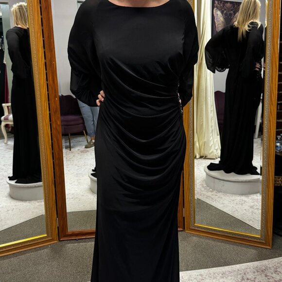 Black jersey gown with puff sleeves beaded waist & flattering side pleats.